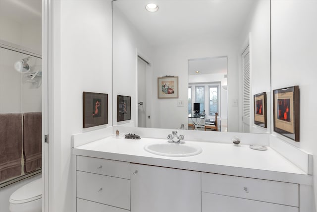 full bathroom featuring toilet, vanity, and shower / bath combination with glass door