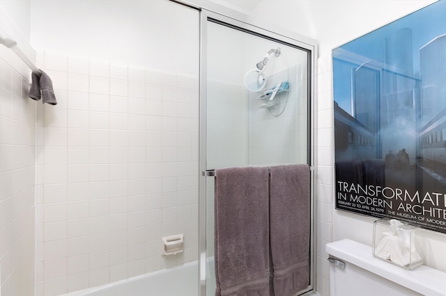 bathroom featuring toilet and tiled shower / bath