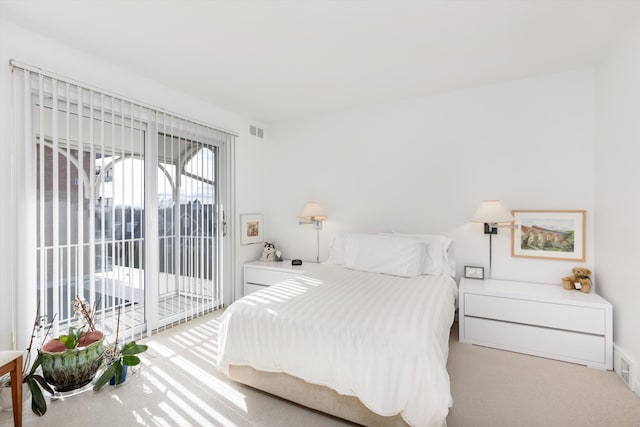 bedroom with access to exterior, visible vents, and light carpet