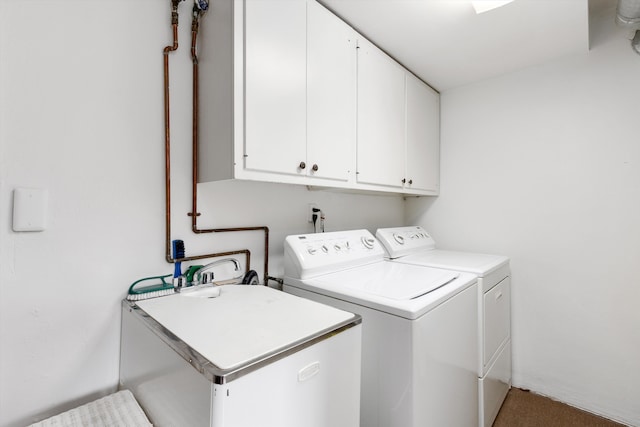 clothes washing area with washing machine and dryer and cabinets