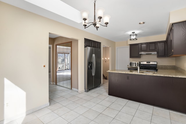 kitchen featuring appliances with stainless steel finishes, decorative light fixtures, a chandelier, light tile patterned floors, and dark brown cabinets