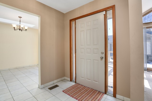 tiled foyer entrance with a notable chandelier