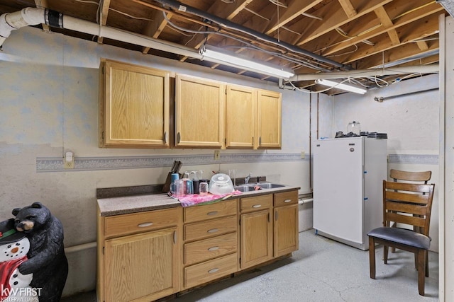 interior space with white refrigerator, light brown cabinetry, and sink