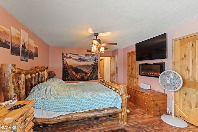 bedroom with wood-type flooring, ceiling fan, and a textured ceiling