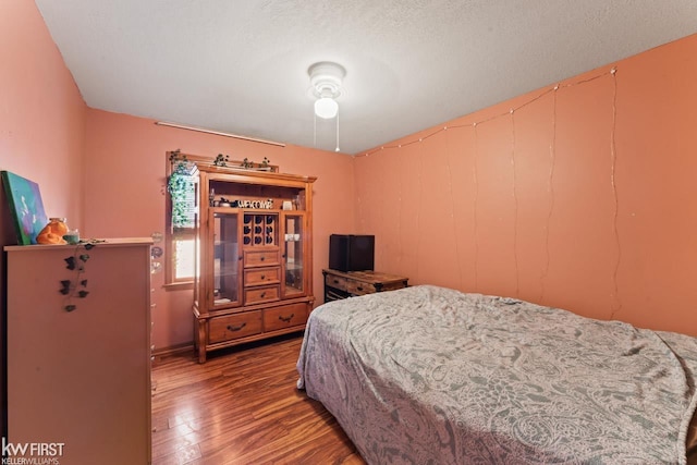 bedroom with wood-type flooring and a textured ceiling