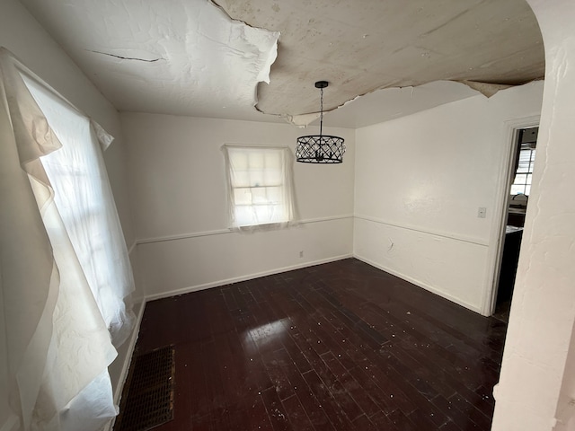 unfurnished dining area with a healthy amount of sunlight and dark hardwood / wood-style flooring