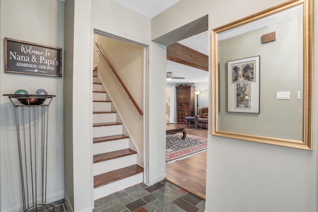 stairs with beamed ceiling and wood-type flooring