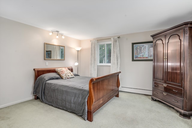 bedroom with a baseboard heating unit and light colored carpet