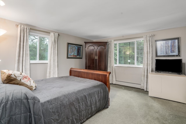 carpeted bedroom featuring multiple windows and a baseboard heating unit