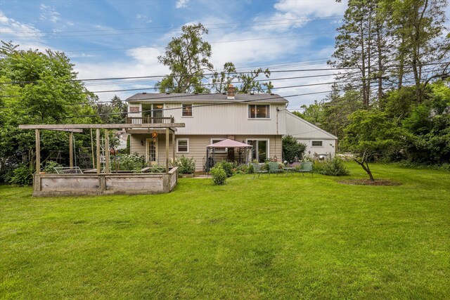 back of property with a balcony and a yard