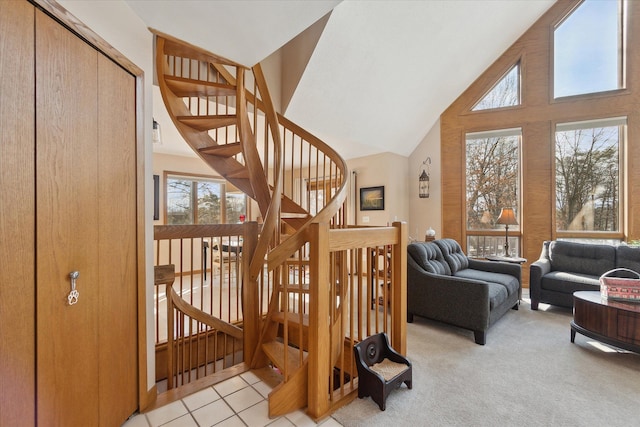 stairs with carpet floors and high vaulted ceiling