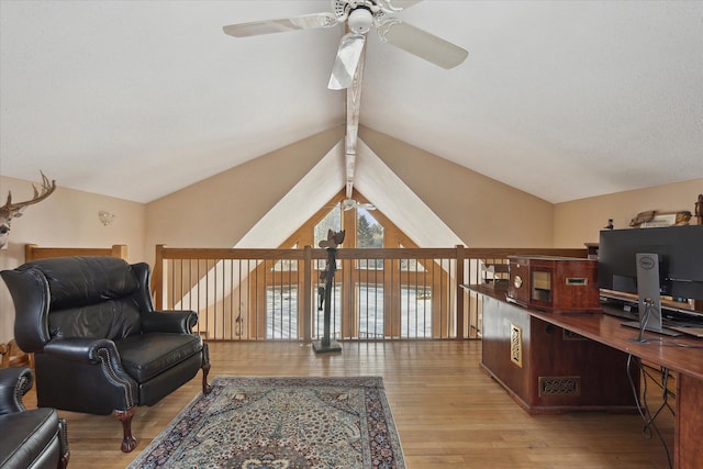 living area featuring ceiling fan, lofted ceiling with beams, and light hardwood / wood-style flooring