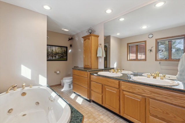 bathroom featuring vanity, a tub to relax in, tile patterned flooring, and toilet