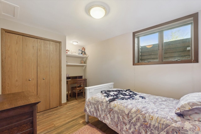 bedroom with light hardwood / wood-style floors and a closet