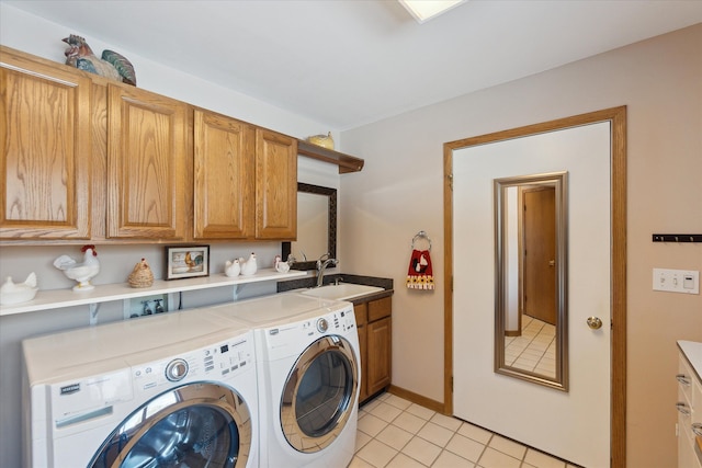 laundry area with cabinets, sink, washing machine and dryer, and light tile patterned floors