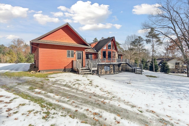 snow covered property with a wooden deck