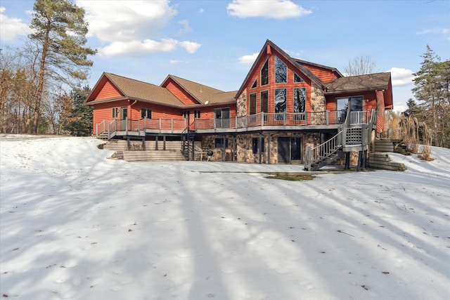 snow covered property with a deck