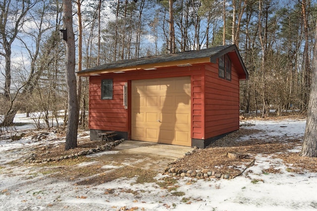 snow covered structure with a garage