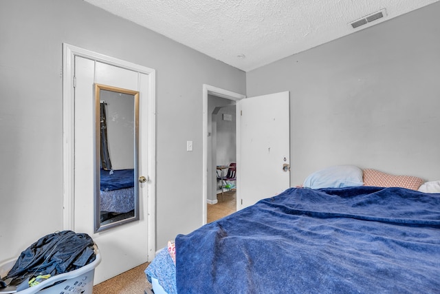 carpeted bedroom featuring a textured ceiling