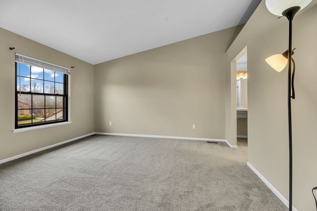 carpeted spare room featuring vaulted ceiling