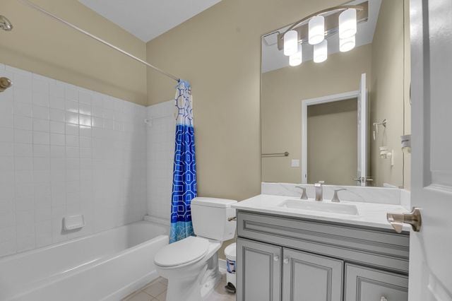 full bathroom with vanity, tile patterned flooring, toilet, and shower / bathtub combination with curtain