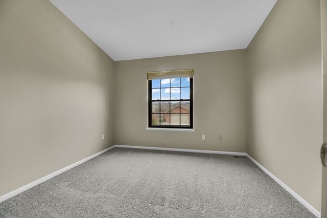 empty room with lofted ceiling and carpet floors