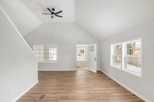 unfurnished living room featuring lofted ceiling, ceiling fan, and light hardwood / wood-style flooring