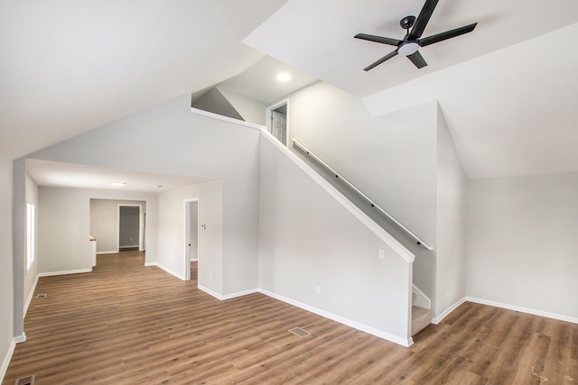 stairs featuring hardwood / wood-style flooring, ceiling fan, and high vaulted ceiling