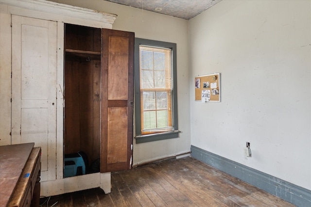 unfurnished bedroom featuring dark hardwood / wood-style flooring and a closet