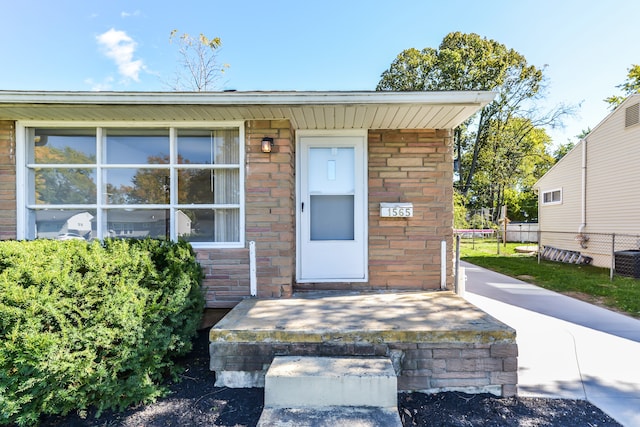 property entrance with stone siding and fence