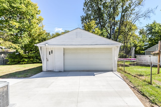 detached garage with a trampoline and fence