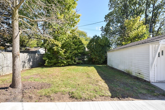 view of yard featuring fence and an outbuilding