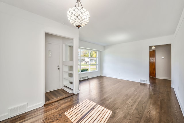 interior space with dark wood-style floors, visible vents, and baseboards