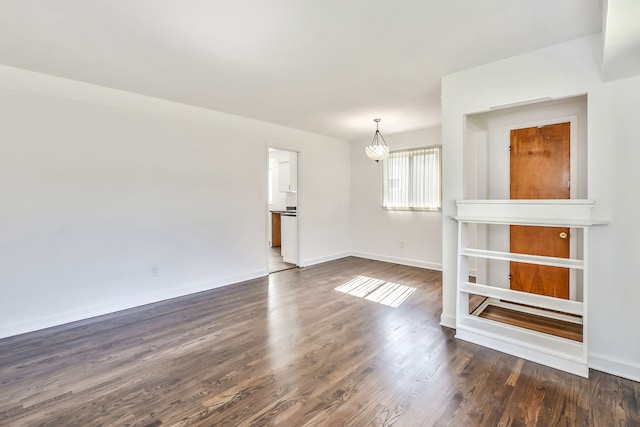 unfurnished room with dark wood-style floors and baseboards