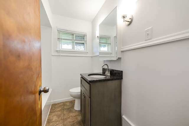 bathroom featuring vanity, toilet, and baseboards