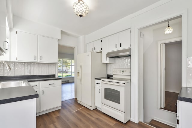 kitchen featuring dark wood-style floors, dark countertops, a sink, white appliances, and under cabinet range hood