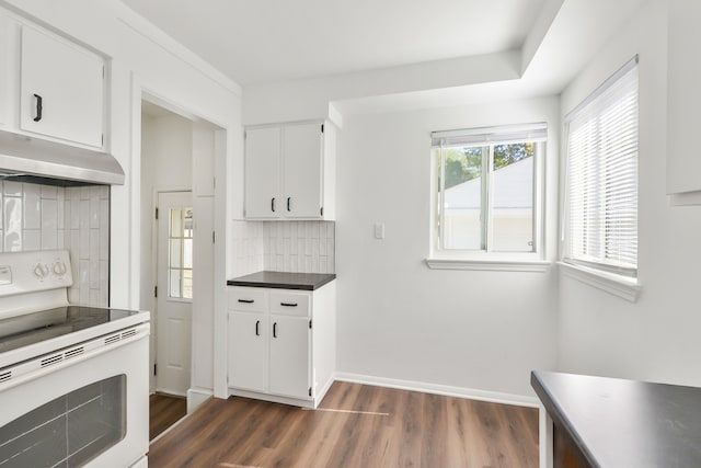 kitchen with white electric stove, dark wood-type flooring, baseboards, white cabinets, and range hood