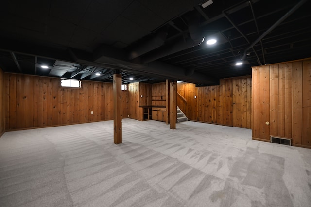 basement with carpet, visible vents, and stairs