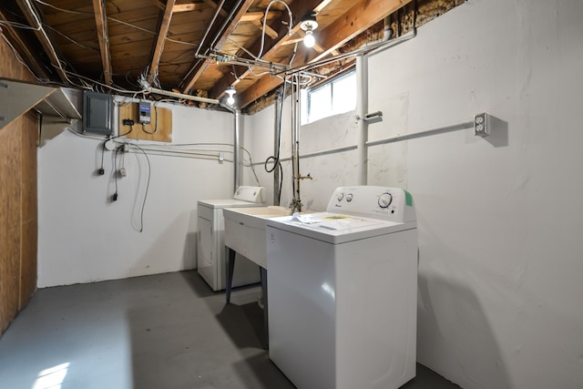 washroom with laundry area, electric panel, a sink, and washer and clothes dryer