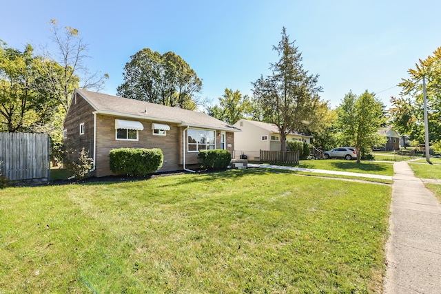 view of front of property featuring fence and a front lawn