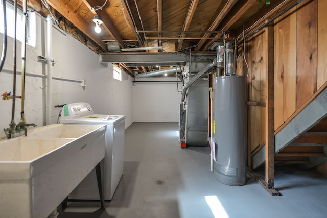 basement featuring a sink, heating unit, washer / clothes dryer, and gas water heater