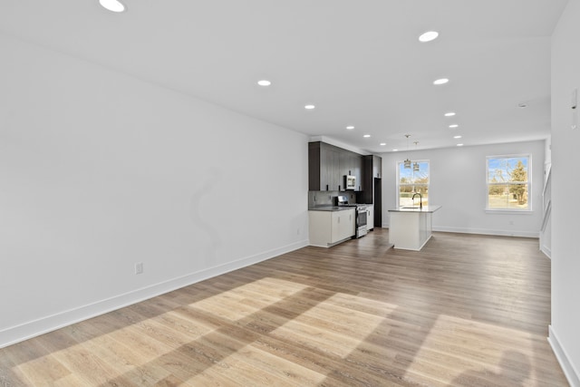 unfurnished living room with sink and light wood-type flooring