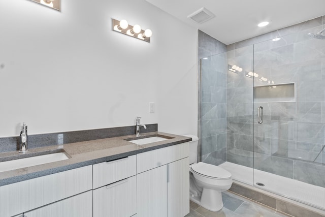 bathroom with vanity, a shower with shower door, tile patterned floors, and toilet