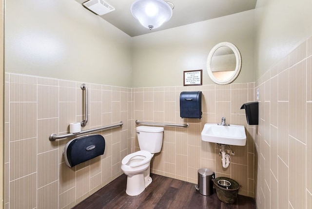 bathroom featuring toilet, hardwood / wood-style floors, and tile walls