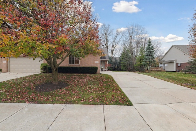 view of property hidden behind natural elements featuring a garage and a front yard