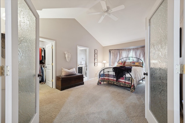 bedroom with carpet, ceiling fan, vaulted ceiling, and a walk in closet