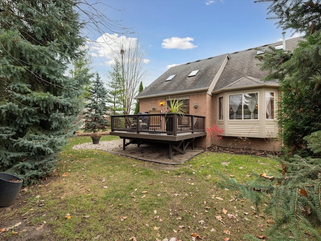 rear view of property featuring a yard and a deck