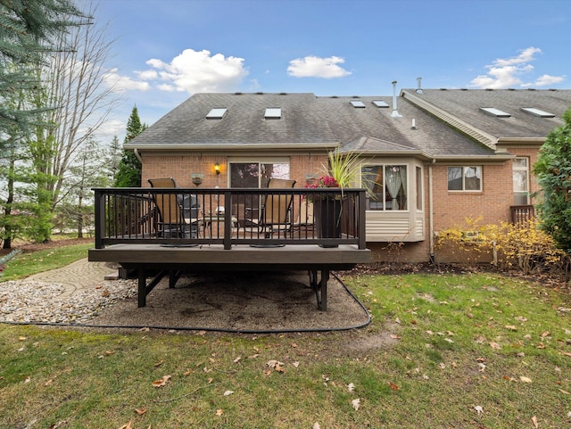 rear view of property featuring a deck and a lawn