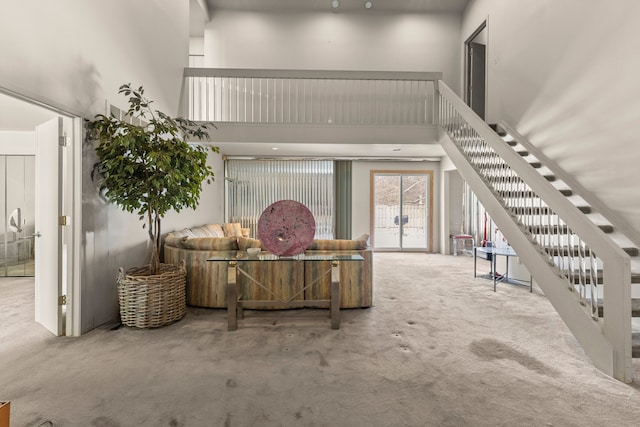 carpeted living room with a towering ceiling