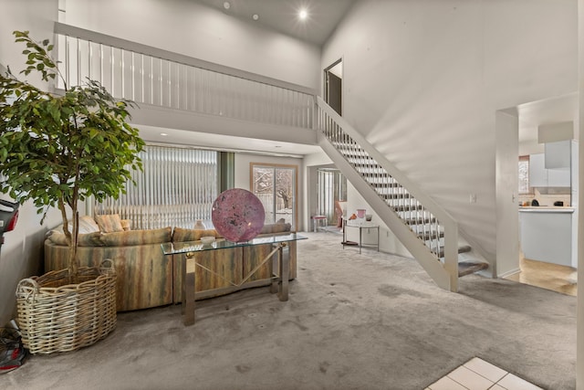 living room featuring light carpet and a high ceiling